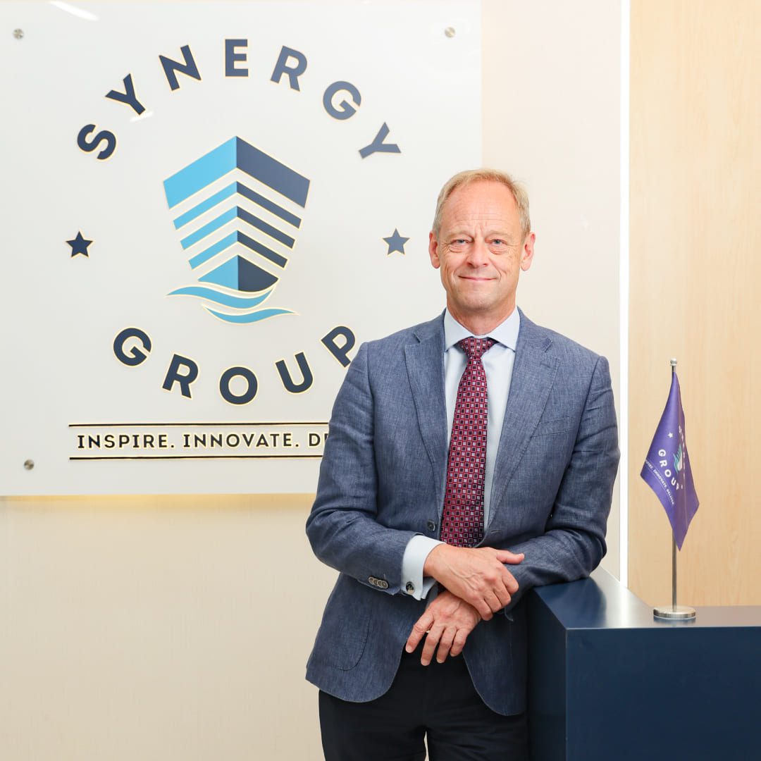 Jesper Kristensen, Group CEO of Synergy Marine Group, photographed in front of a wall featuring the company logo.