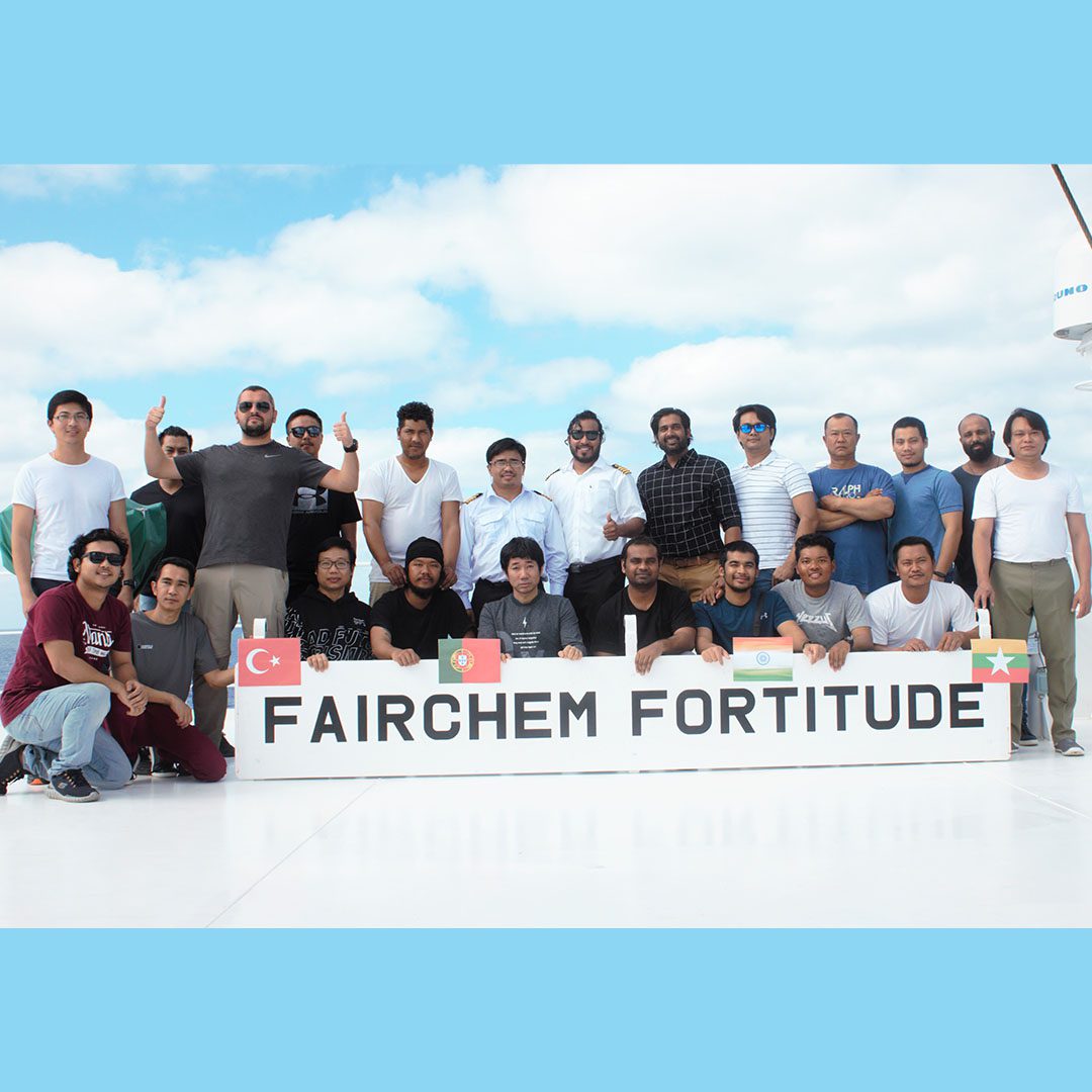 一群多元化的船员在&ldquo;FAIRCHEM FORTITUDE&rdquo;号船甲板上，蓝天下合影。