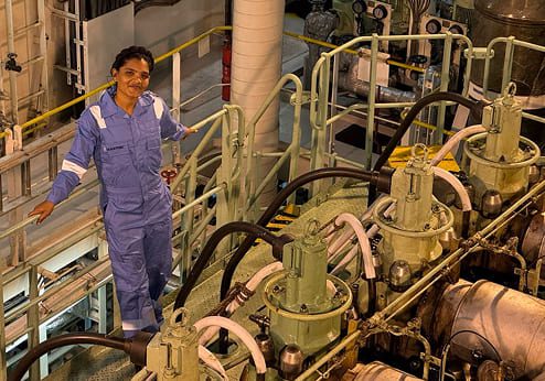 Engine Cadet Jaishni Jayakumar inspecting equipment in a ship engine room