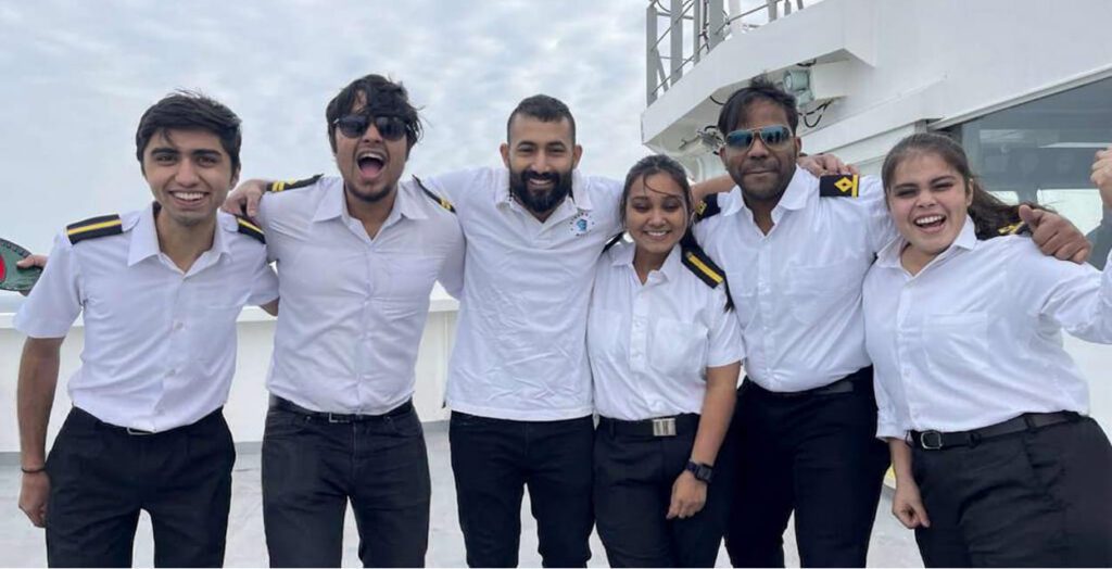 Diverse ship crew and officers smiling together on deck showcasing inclusive workplace culture